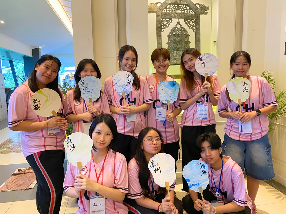 นักเรียนถือพัดจีนที่มีชื่อเมืองต่าง ๆ ในกิจกรรมฐานวัฒนธรรมจีน