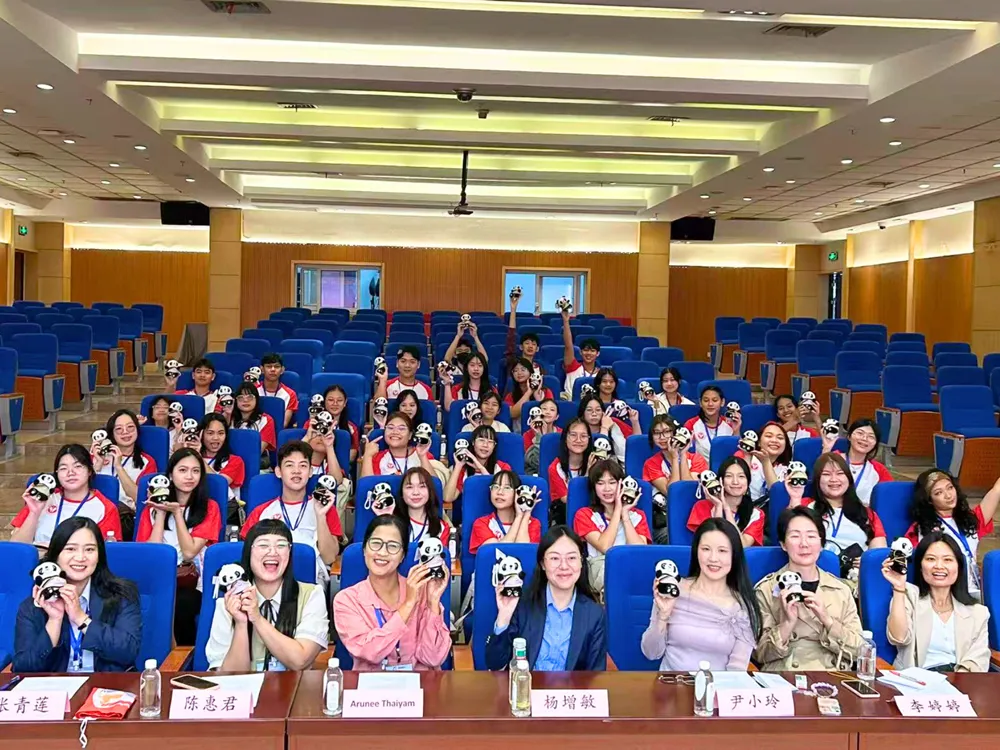 นักเรียน Jinbu ร่วมกิจกรรมในหอประชุม ถือแพนด้าเป็นสัญลักษณ์มิตรภาพจีน-ไทย