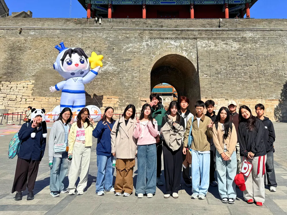 นักเรียนไทยถ่ายภาพหมู่หน้าประตูหินโบราณในจีน ระหว่างโครงการ Live & Learn in China รอบมีนาคม–เมษายน 2569