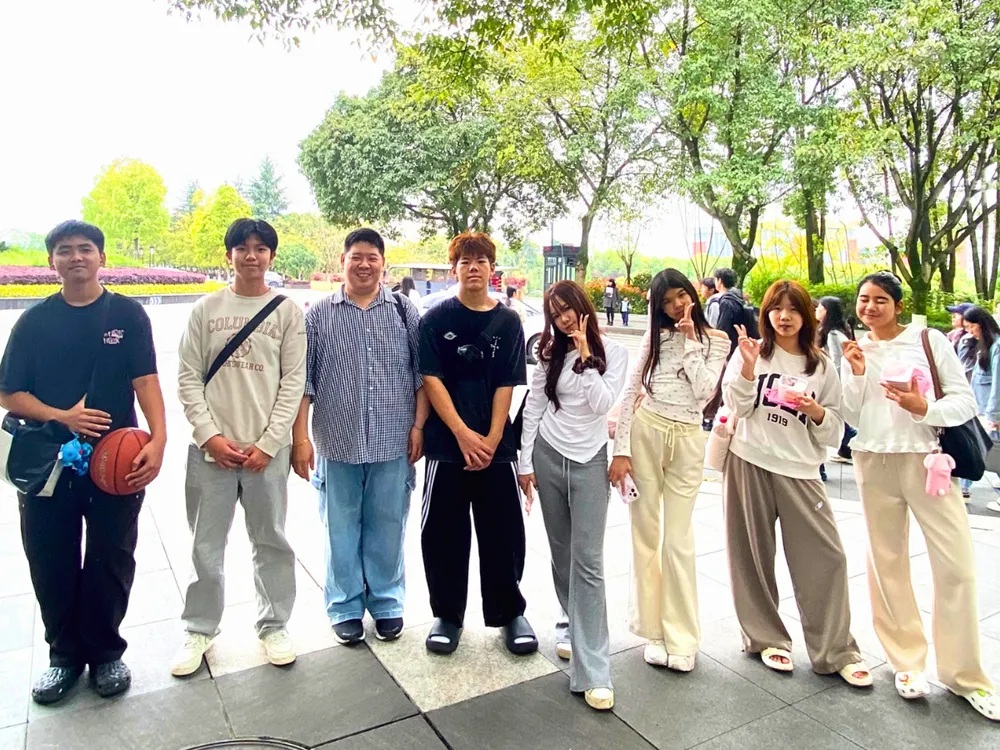 นักเรียนไทยถ่ายภาพกลุ่มในสวนมหาวิทยาลัยจีน บรรยากาศสบาย ๆ ระหว่างโครงการ Live & Learn in China รอบมีนาคม–เมษายน 2569
