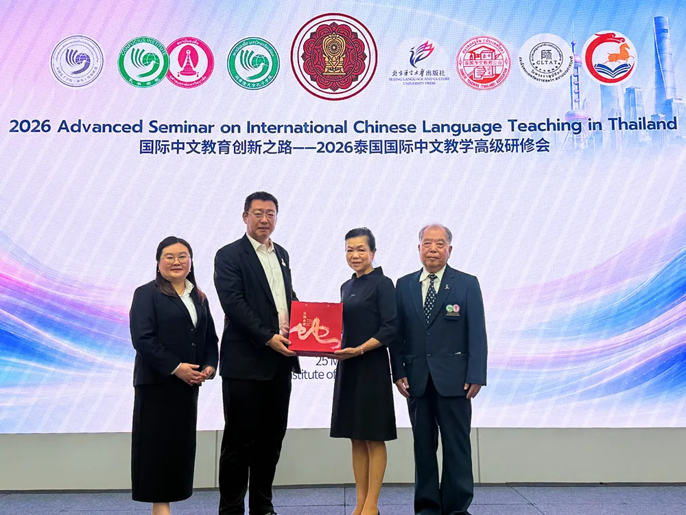 ผู้แทน 4 คนบนเวทีงานอบรมสัมมนาการสอนภาษาจีนนานาชาติ 2026 ถือเอกสารรับรอง