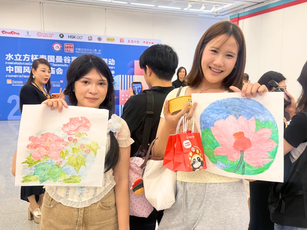 ผู้เข้าร่วมงานนำเสนอผลงานศิลปะวาดภาพดอกไม้ในกิจกรรมวัฒนธรรมจีน