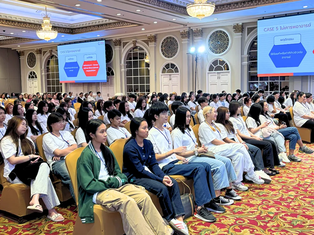 นักศึกษาฟังบรรยายและดูสไลด์การเรียนต่อจีนในห้องประชุมใหญ่