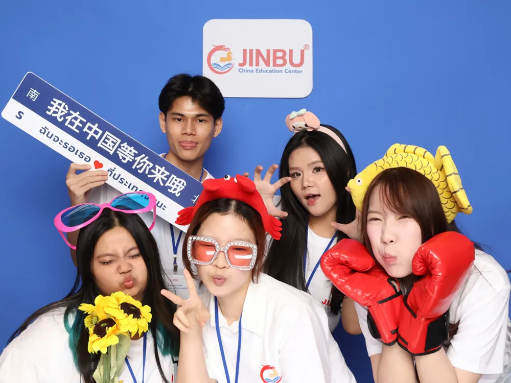 นักศึกษาถ่ายภาพหมู่กับป้าย Jinbu China Education Center พร้อมข้อความ ฉันจะรอเธอที่ประเทศจีน