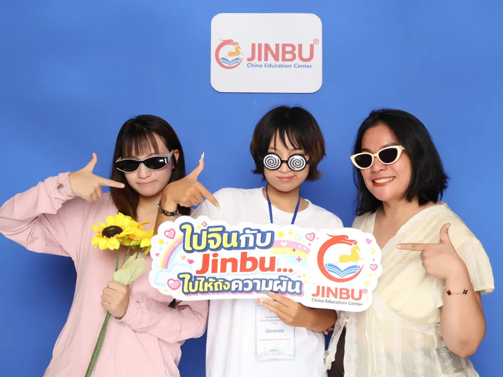 นักศึกษาถ่ายภาพกับป้าย Jinbu China Education Center พร้อมข้อความ ไปจีนกับ Jinbu ไปให้ถึงความฝัน