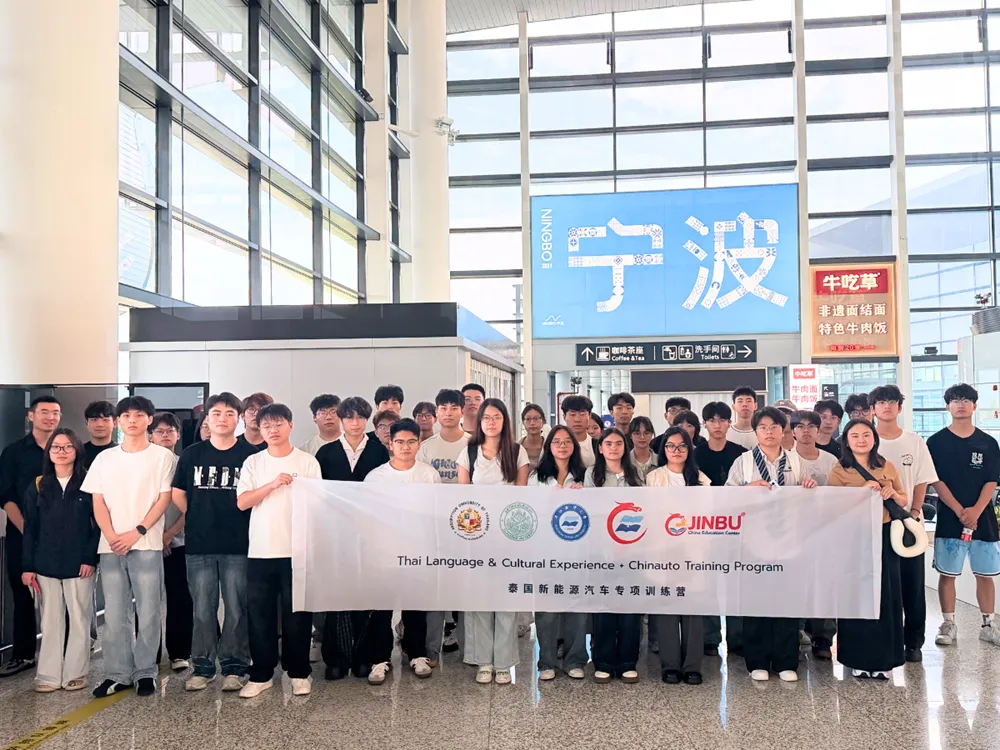 นักศึกษาจีนถือแบนเนอร์ Thai Language & Cultural Experience + Chinauto Training Program ณ เมืองหนิงโป