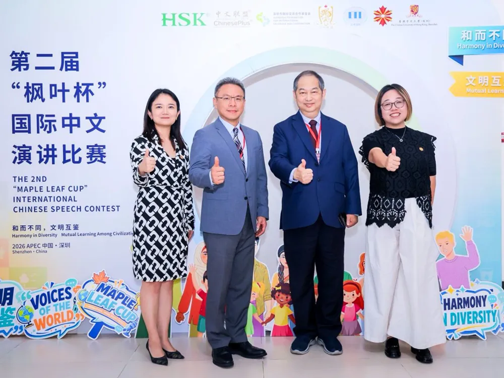 ผู้เข้าร่วมงาน Maple Leaf Cup International Chinese Speech Contest ถ่ายภาพหน้าป้าย Harmony in Diversity