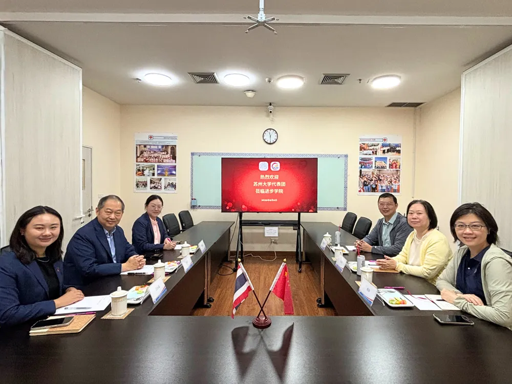 การประชุมระหว่างผู้แทนมหาวิทยาลัยซูโจวและ Jinbu ในห้องประชุม พร้อมธงไทย–จีนบนโต๊ะ