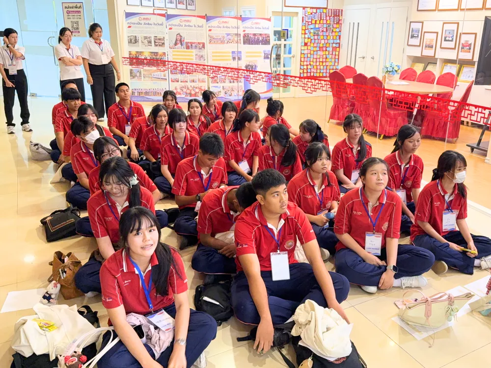 นักเรียนโรงเรียนถาวรานุกูลสวมเสื้อค่ายสีแดง นั่งเรียนรู้กิจกรรมภาษาจีนใน Jinbu Chinese Camp