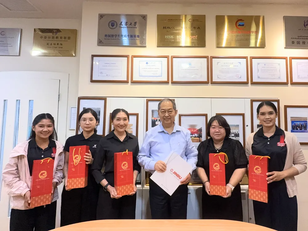 นักเรียนโรงเรียนถาวรานุกูลรับของที่ระลึกและถ่ายภาพหน้ากำแพงเกียรติบัตร Jinbu Chinese Camp