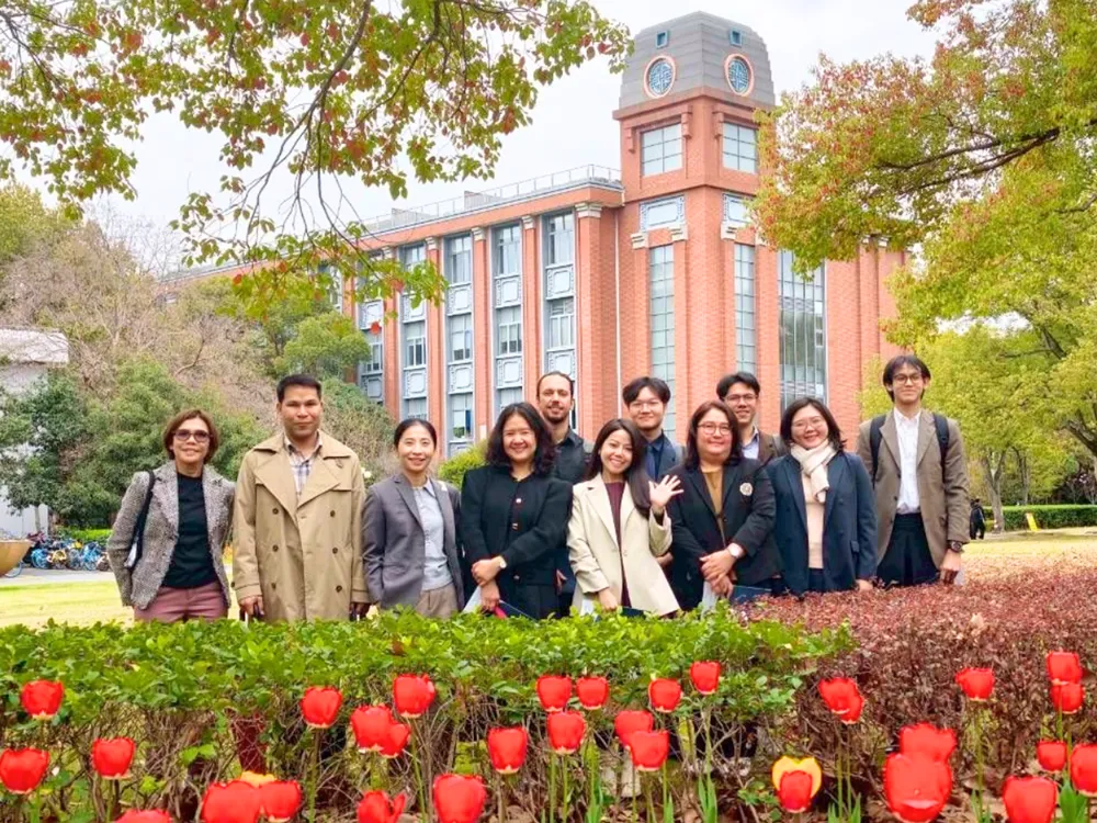 คณะอาจารย์ไทยถ่ายภาพหมู่หน้าตึกมหาวิทยาลัยจีนพร้อมสวนดอกทิวลิป