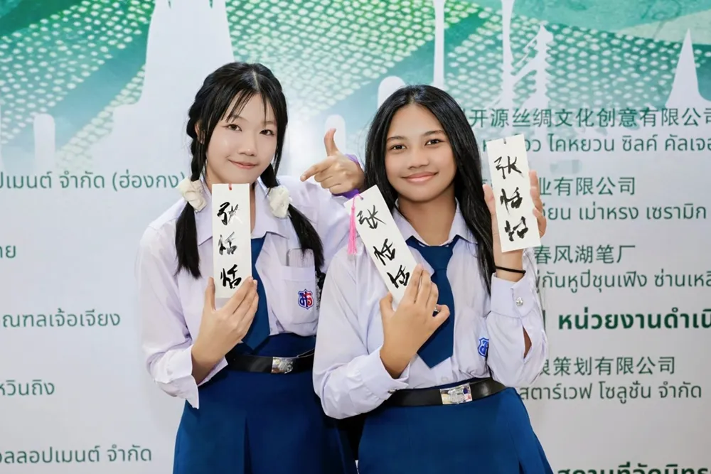 นักเรียนไทยถือกระดาษเขียนพู่กันจีน ร่วมกิจกรรมศิลปะอักษรจีน กรุงเทพฯ