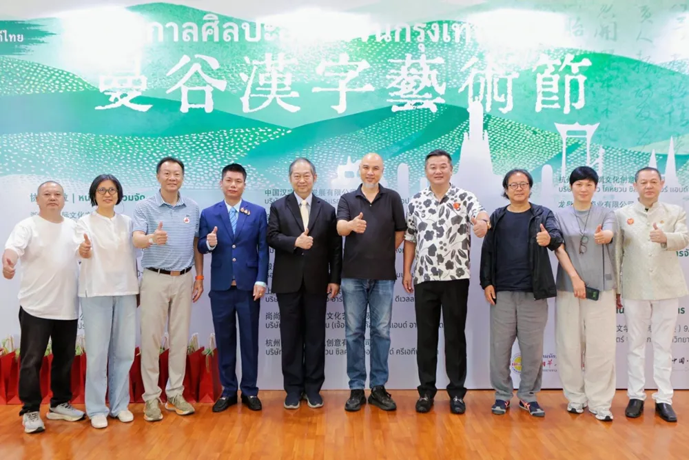 ผู้บริหารและผู้เข้าร่วมงานเทศกาลศิลปะอักษรจีน ถ่ายภาพหมู่หน้าป้ายงาน