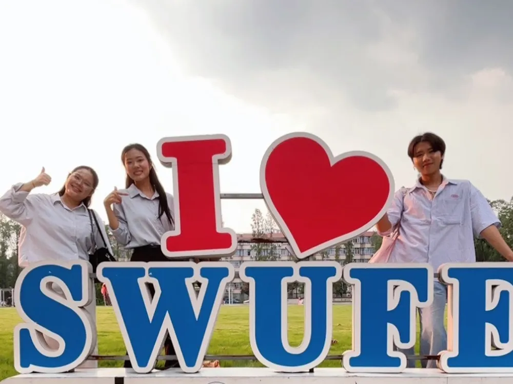 นักเรียน Jinbu ถ่ายภาพหน้าสัญลักษณ์ Southwestern University of Finance and Economics